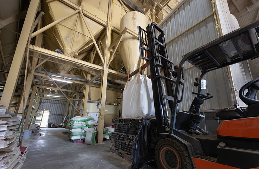 Forklift handling bulk bags in warehouse