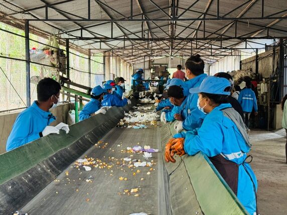 Workers sorting recyclable materials at an industrial facility